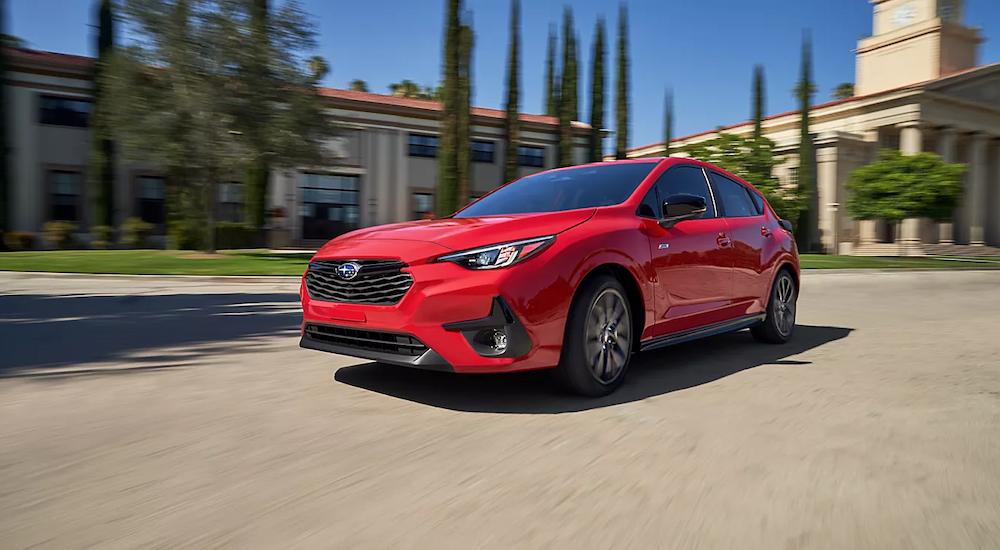 Red 2024 Subaru Impreza driving on a city street