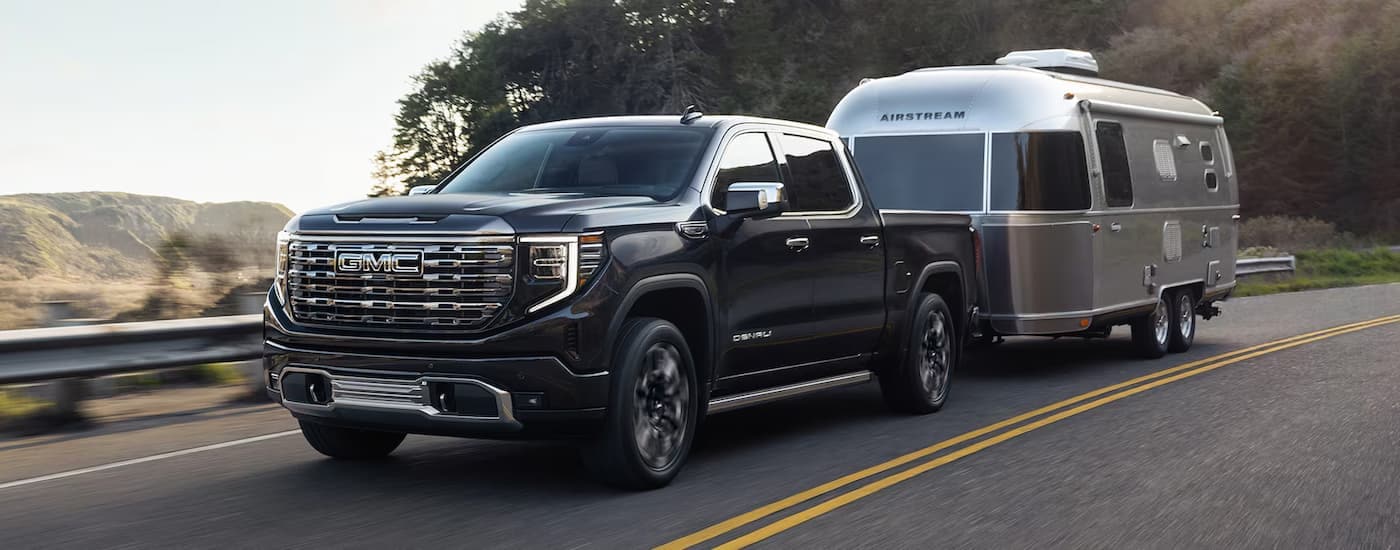 Trucks%20for%20Sale%20Near%20Sandy%20Springs%202025%20GMC%20Sierra%201500%20Denali%20-%20Towing.jpg Black 2025 GMC Sierra 1500 Denali towing a silver Airstream trailer