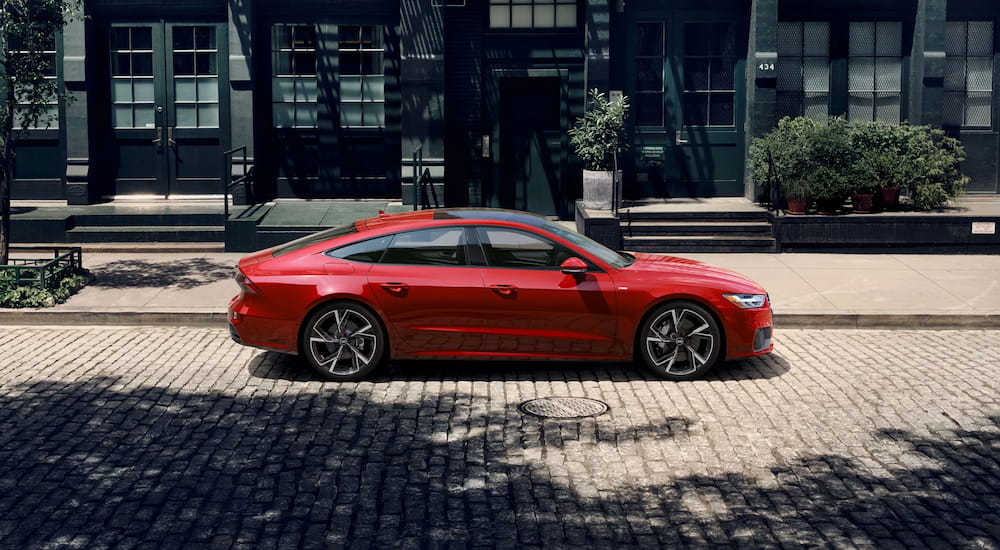 Side of a red 2025 Audi A7 parked by a curb.
