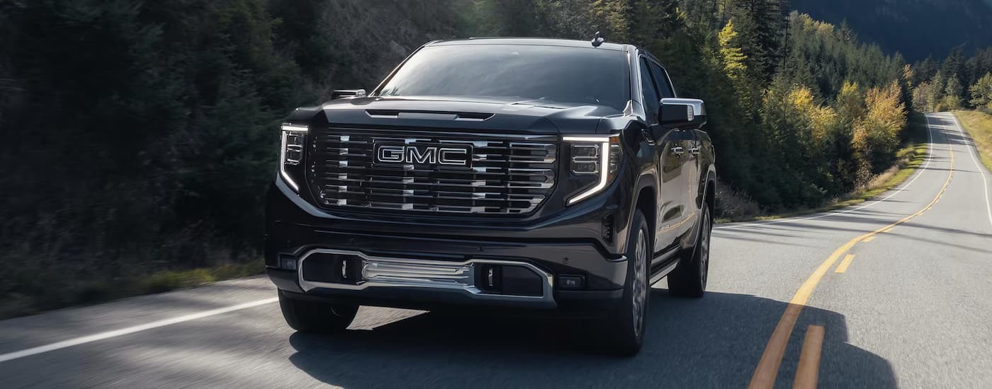 Trucks%20for%20Sale%20Near%20Wake%20Forest%20-%202025%20GMC%20Sierra%201500%20Denali%20Ultimate%20-%20Black%20copy.jpg Black 2025 GMC Sierra 1500 Denali Ultimate driving on a highway