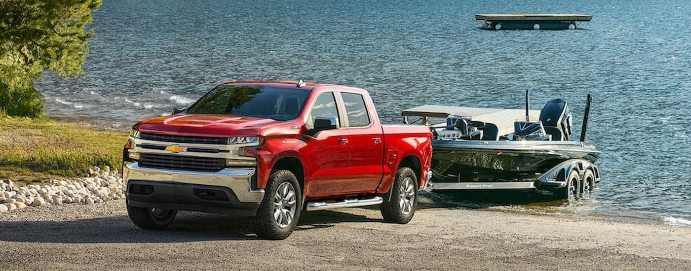 A red 2022 Chevy Silverado 1500 LTD is towing a boat.