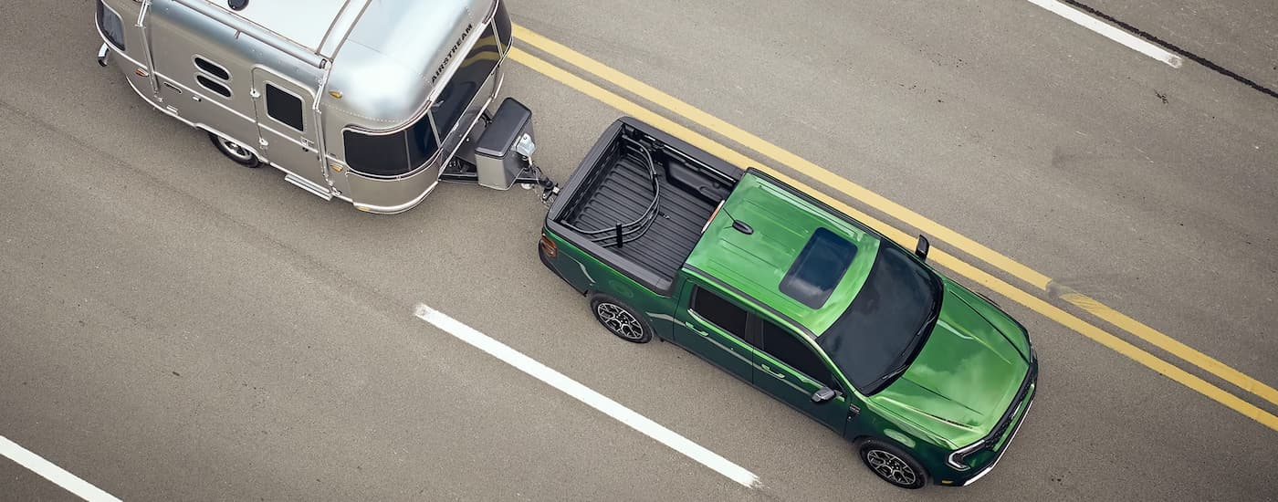 Cars%20for%20Sale%20Near%20Mount%20Pleasant%20Ford%202025%20Ford%20Maverick%20-%20Green.jpg Green 2025 Ford Maverick towing a silver camper trailer