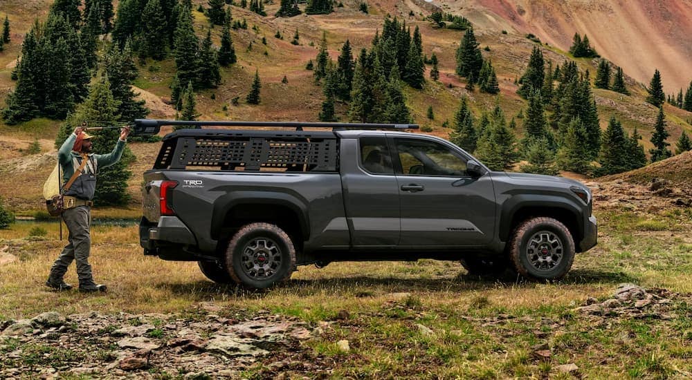 Side of a grey 2025 Toyota Tacoma parked off-road near the mountains