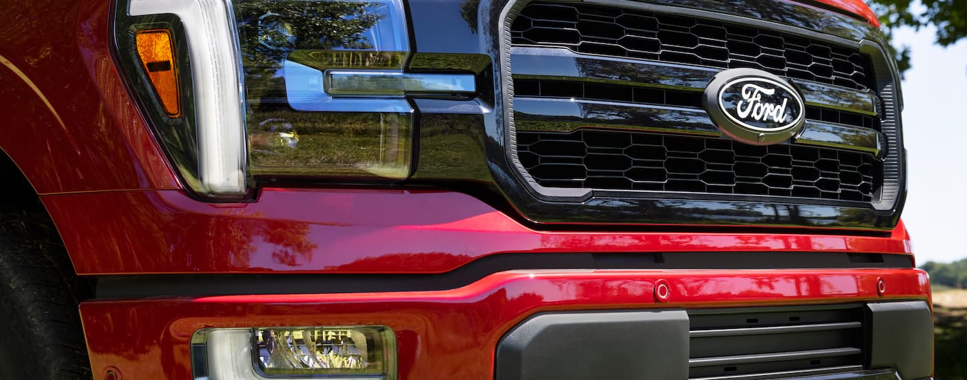 Trucks%20for%20Sale%20Near%20Concord%202024%20Ford%20F-150%20Lariat%20Red.jpg Grille on a red 2024 Ford F-150 Lariat