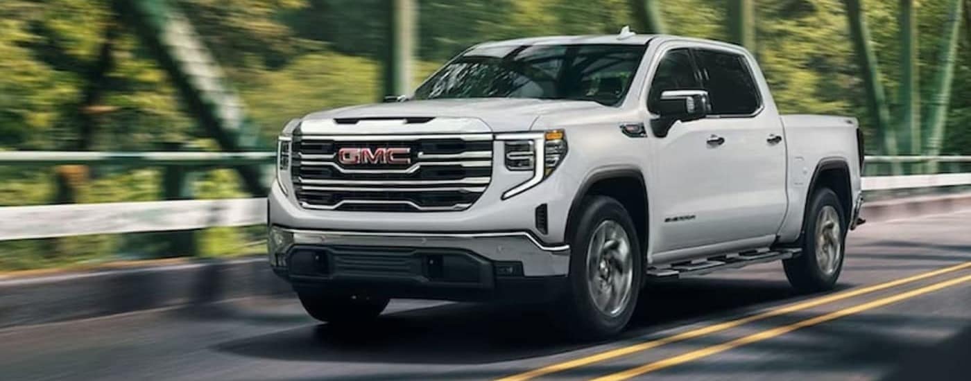A white 2024 GMC Sierra 1500 driving to view trucks for sale.