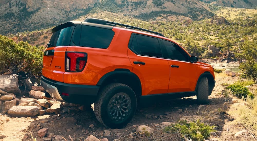 Orange 2026 Honda Passport TrailSport parked off-road.
