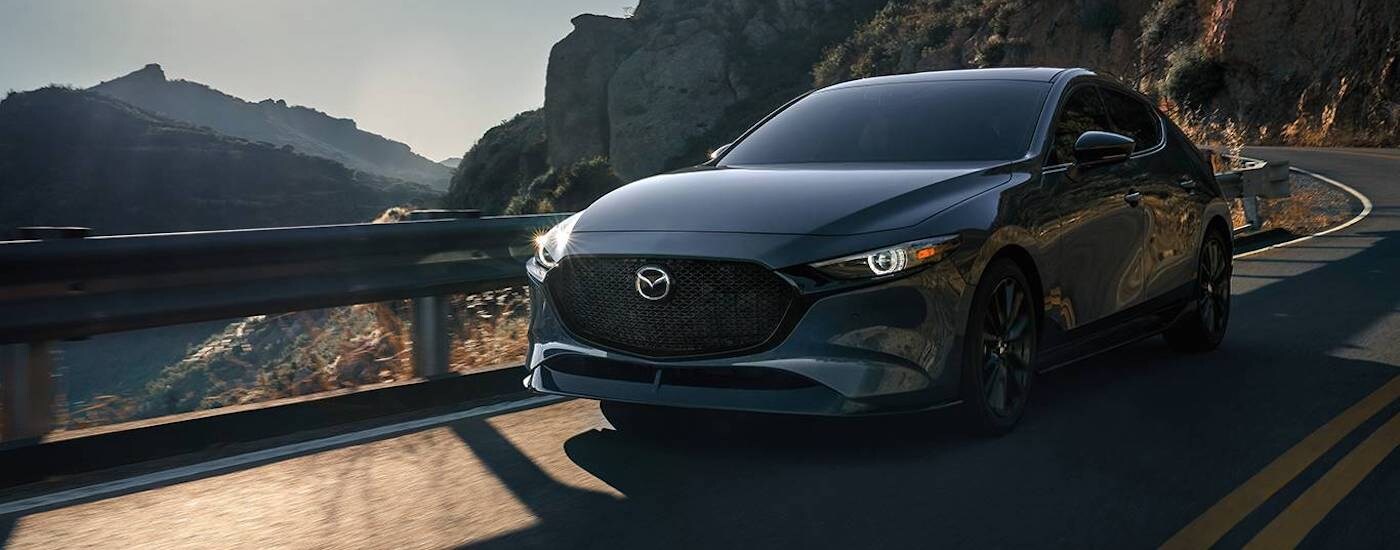 A grey 2022 Mazda3 is shown from the front at an angle after leaving a car dealer near Roswell.