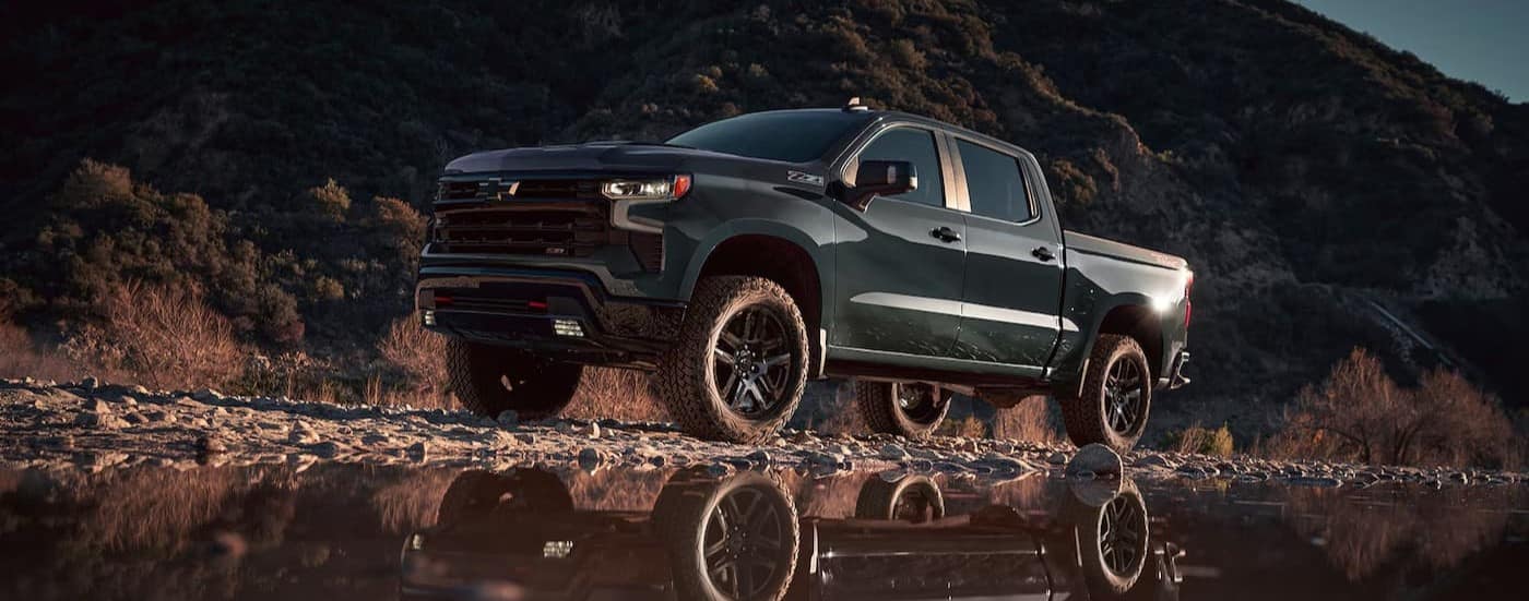 A green 2025 Chevy Silverado 1500 Z71 parked near water.